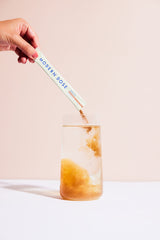 Modern Dose Sleep Aid Salted Caramel stick pack powder being poured into a glass of water - moderndose.com