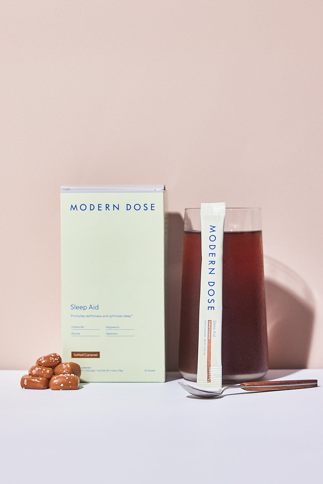 Modern Dose Sleep Aid Salted Caramel box, stick pack, and drink with salted caramel and a spoon