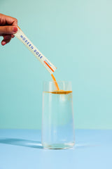 Modern Dose Joint Support Citrus stick pack powder being poured into a glass of water - www.moderndose.com
