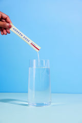 pouring Modern Dose Biotic Blend powder into a glass of water - moderndose.com